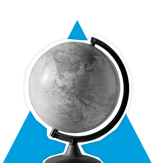 Desk globe showing world map placed in front of blue triangle shape